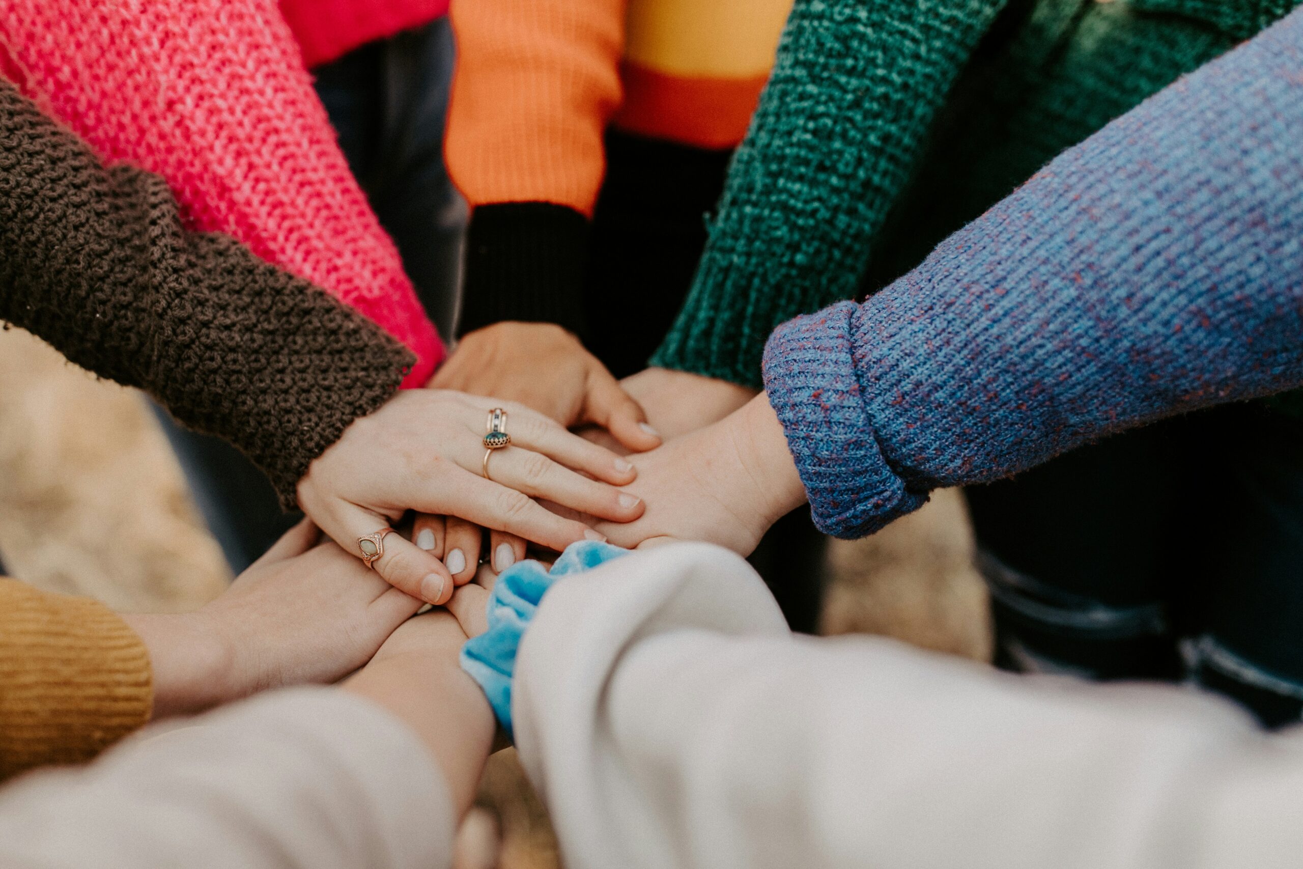 team members touching hands in a circle